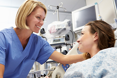A woman in Emergency Room care being comforted by a staff member.