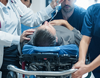 Nurses and Doctor rushing a male patient on a stretcher to the Emergency Room